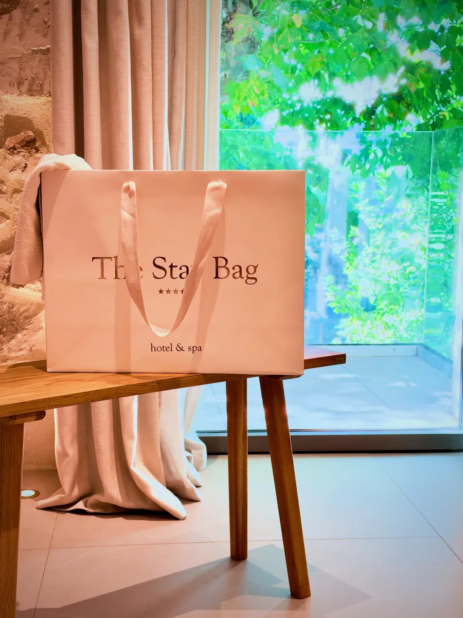The Stay Bag et ses anses, posé sur un banc face à la fenêtre