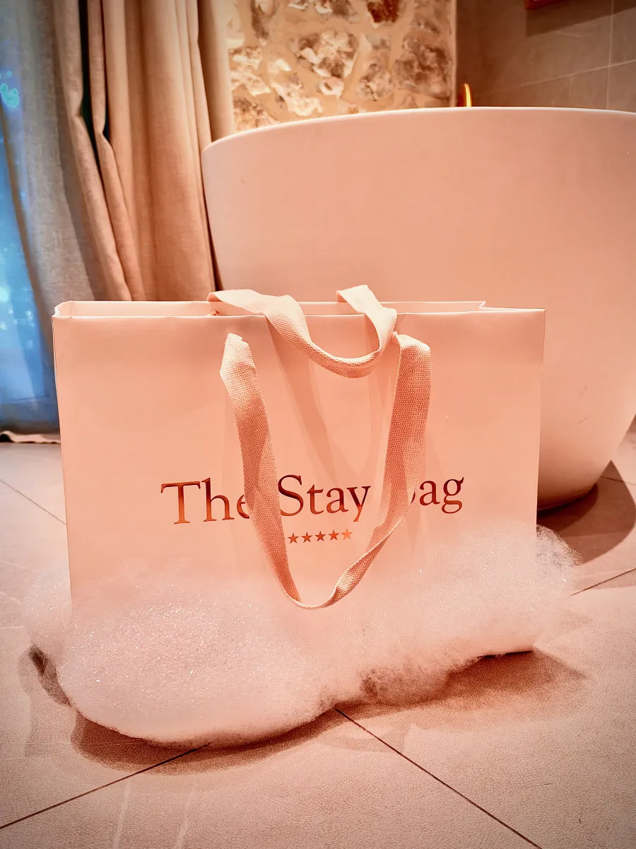 The Stay Bag et sa dorure au bord d'une baignoire remplie de mousse