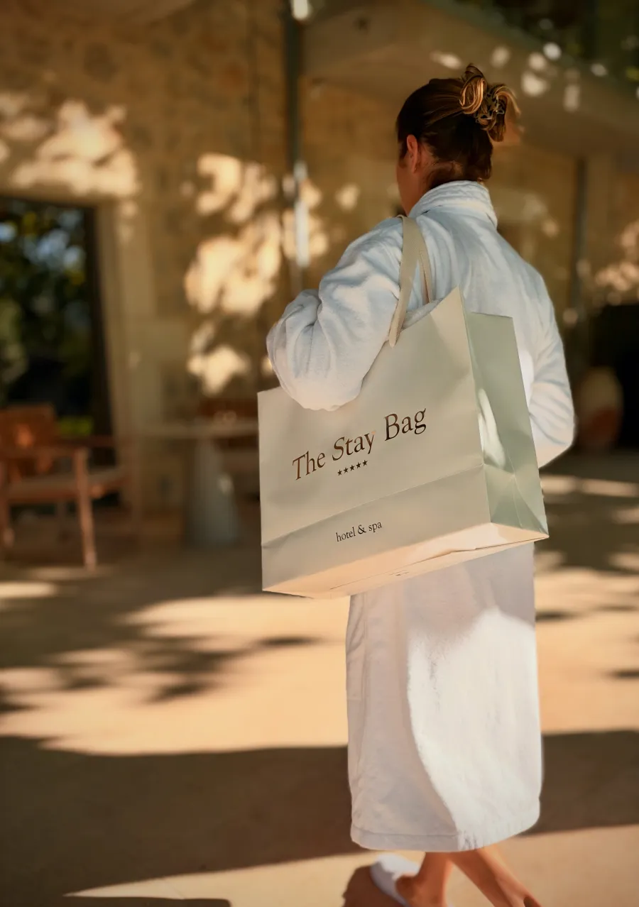 Cliente portant The Stay Bag à l'épaule en quittant le spa
