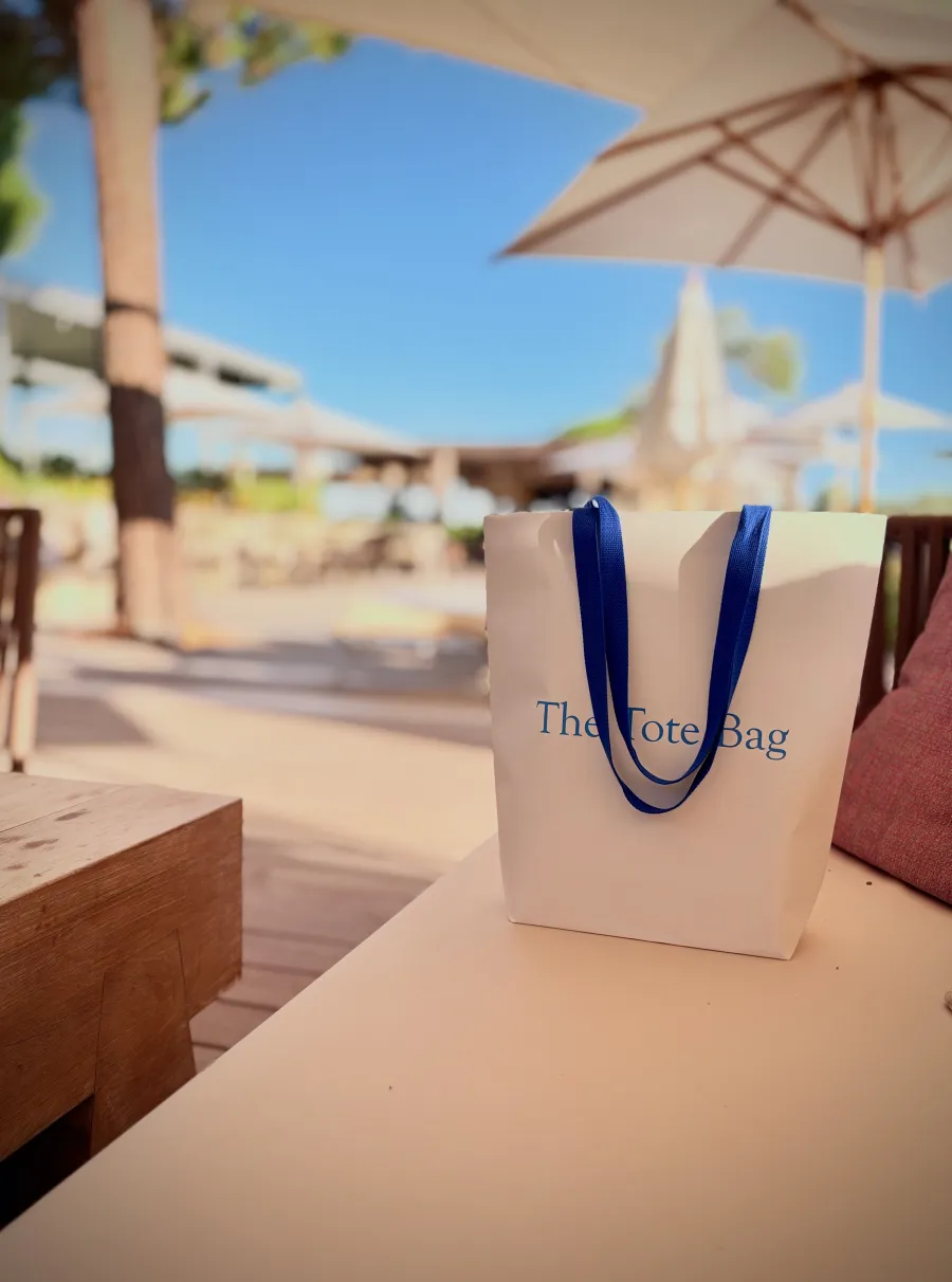 The Tote Bag debout sur une banquette, sous les parasols